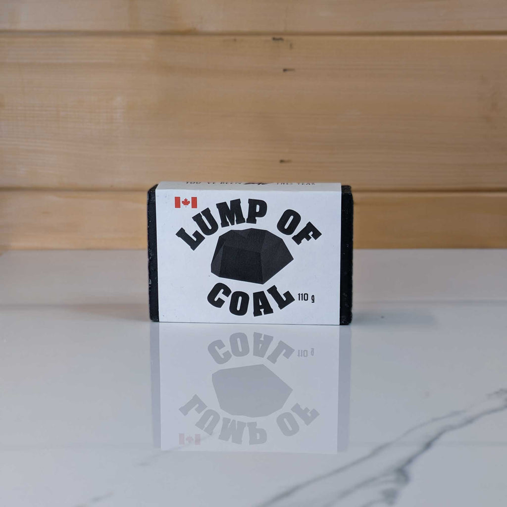 Lump of Coal charcoal soap by PoCo Soap Co. in black and white packaging. The perfect holiday stocking stuffer made with activated charcoal and skin-nourishing shea butter.