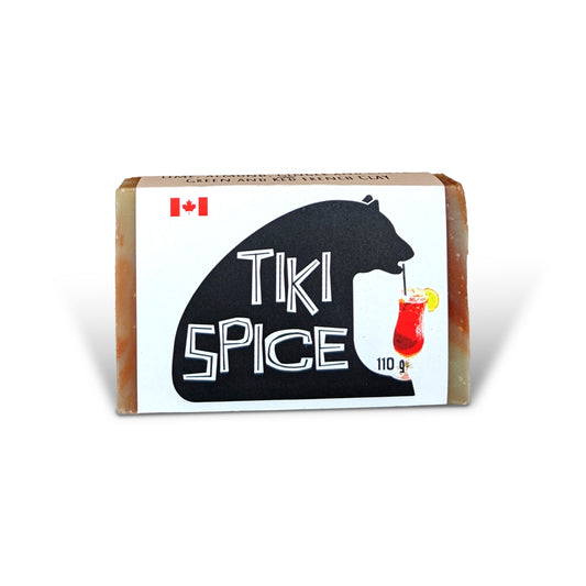 Tiki Spice natural soap bar by PoCo Soap Co. in its black and white label. A handcrafted bar featuring red and green French clay swirls with Lime, Almond, Clove and Ginger essential oils.