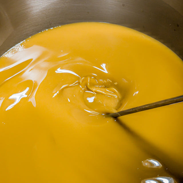 Yellow liquid in a pot with a spoon